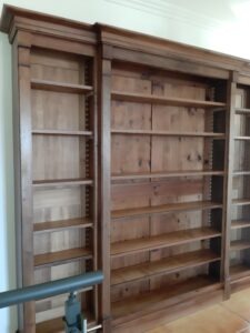 fabrication d'une bibliothèque composé de trois colonnes en noyer avec des étagère sur crémaillère